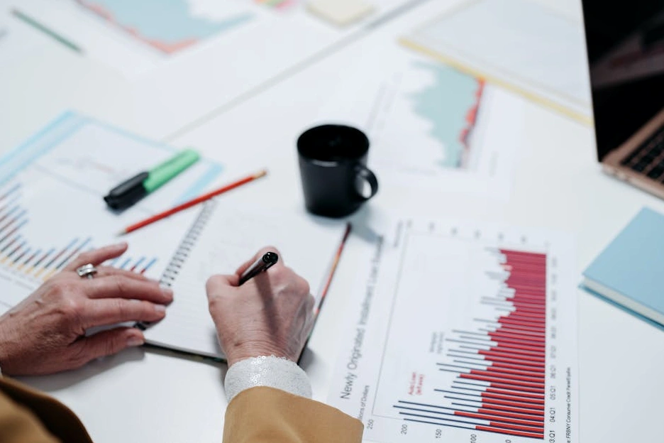 Osoba píšící si poznámky do zápisníku během strategického plánování.